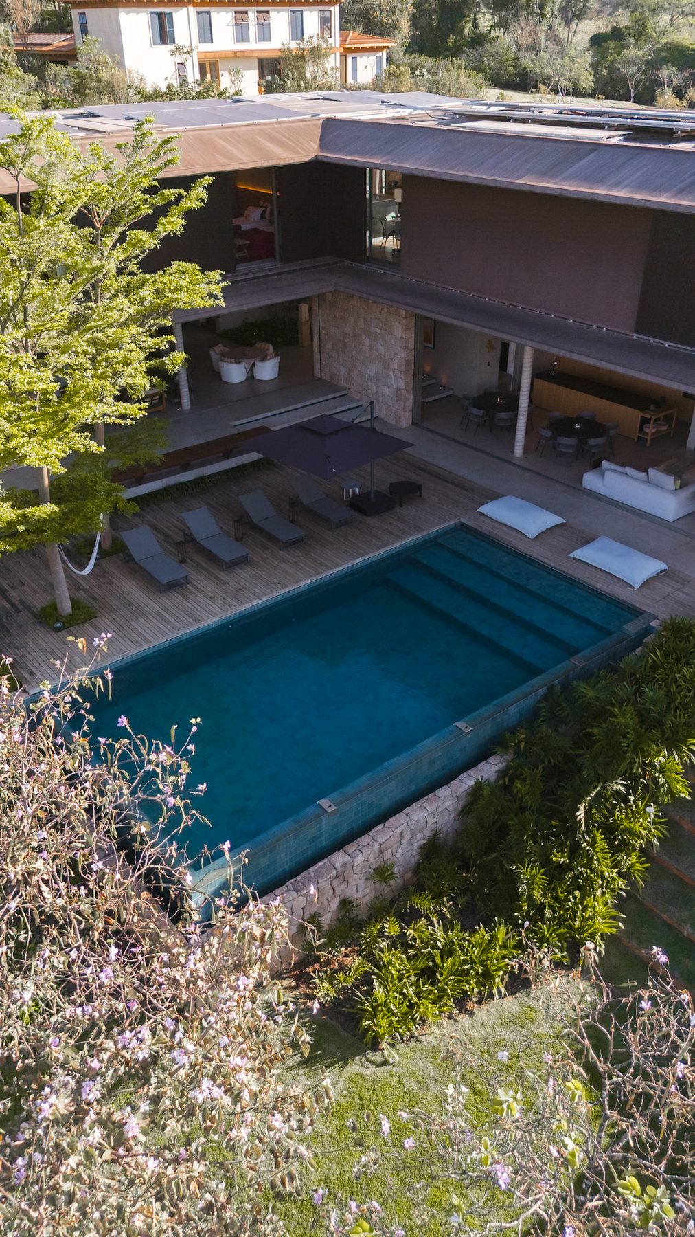 Vista aérea da piscina, do deck com espreguiçadeiras e da varanda da casa