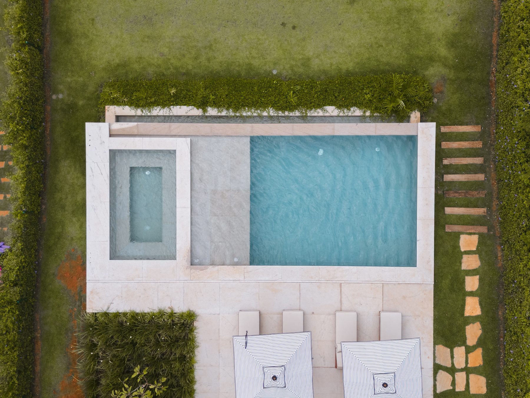 Vista aérea da piscina, da prainha e do deck com guarda-sóis